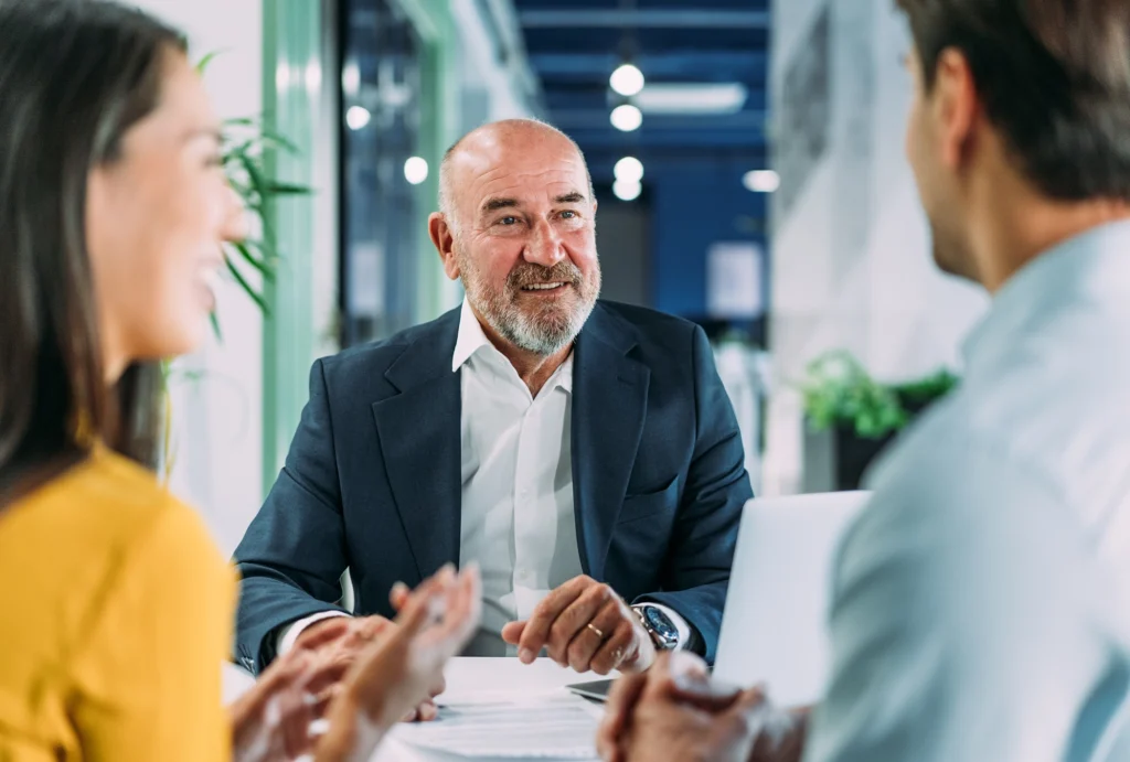 A couple talking with a financial advisor in a conference room