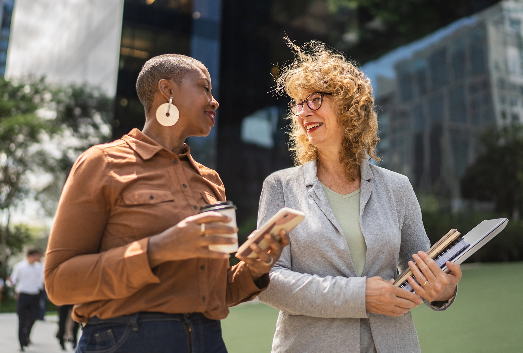 two female business professionals walking and talking