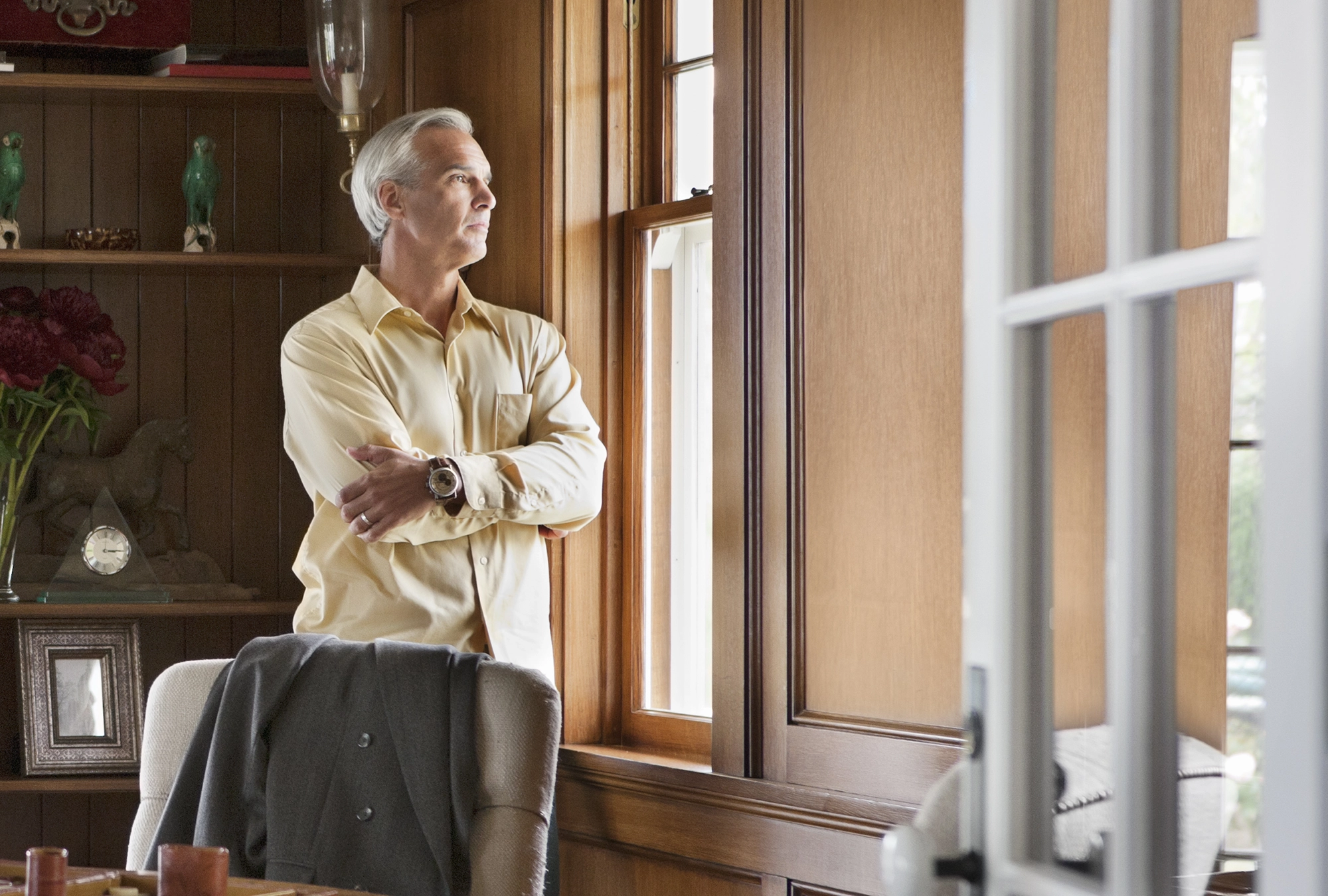 Man looking out the window of a newly inherited house